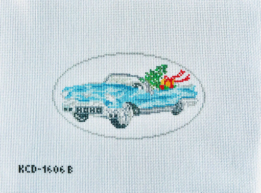 Cross-stitched design of a car with Christmas decorations on fabric.