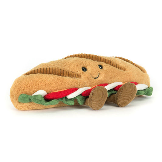 Plush toy shaped like a hot dog with a smiling face on a white background