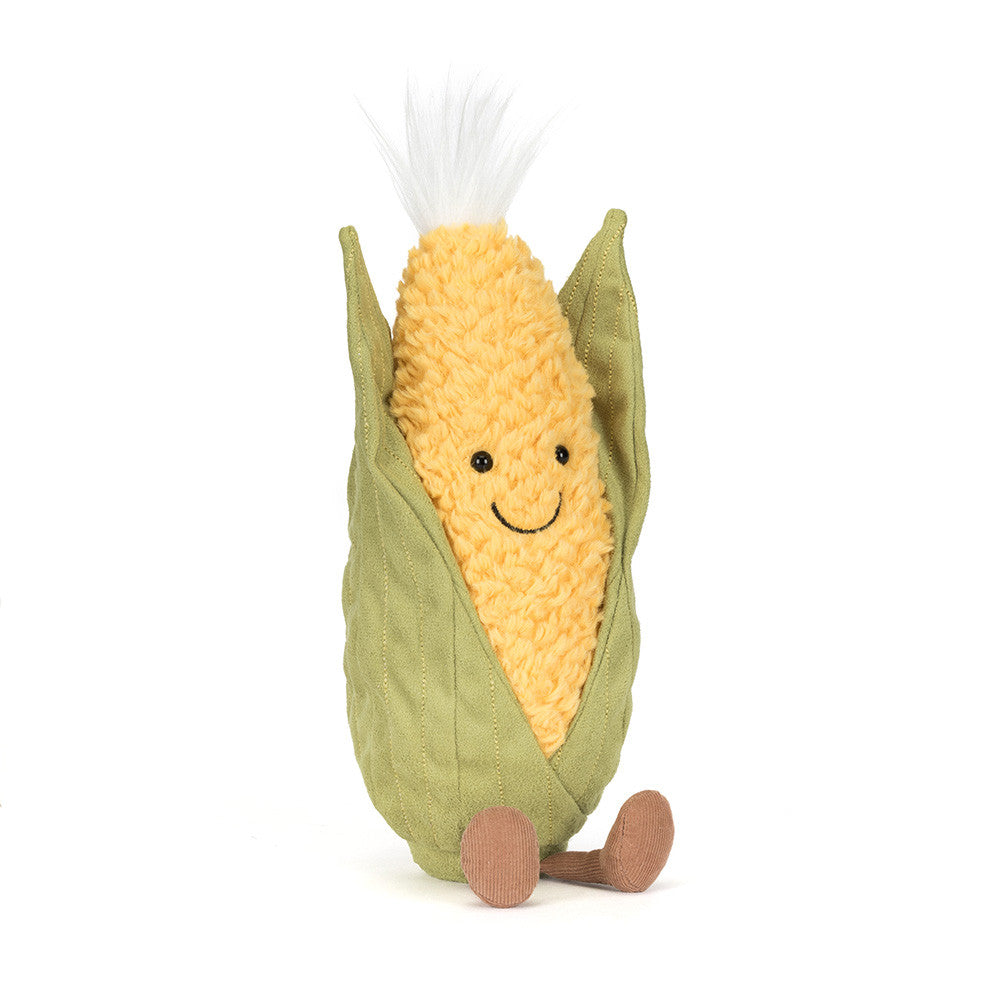 Plush toy resembling a corn on the cob with a smiling face on a white background