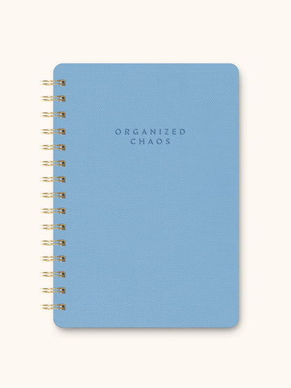 Blue notebook with 'ORGANIZED CHAOS' text on a white background