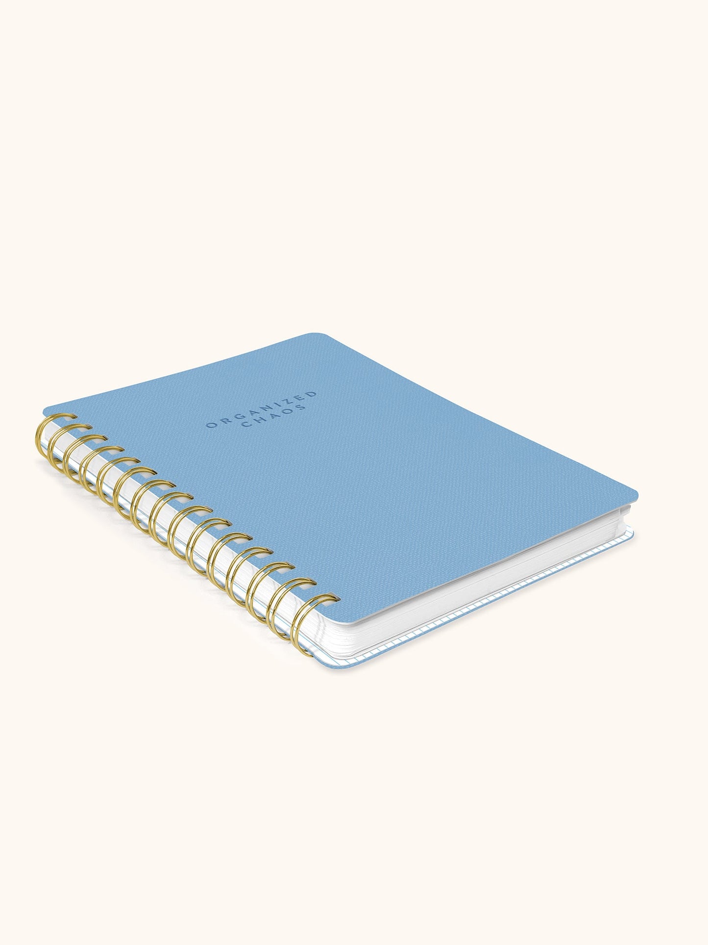 A light blue spiral-bound notebook with gold wire binding and the words 'ORCHIDED STARS' printed on the cover, shown on a warm off-white background.