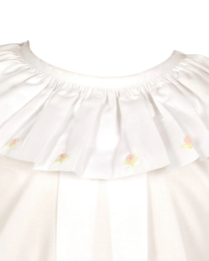 White blouse with ruffled collar and embroidered details on a white background