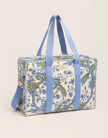 A rectangular duffel bag with a blue and green bird and floral pattern on a cream background, featuring light blue fabric handles and a matching side strap, set against a plain light beige background. Diaper Bag