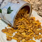 Open can of pet treats spilling onto a white plate with a marble countertop background