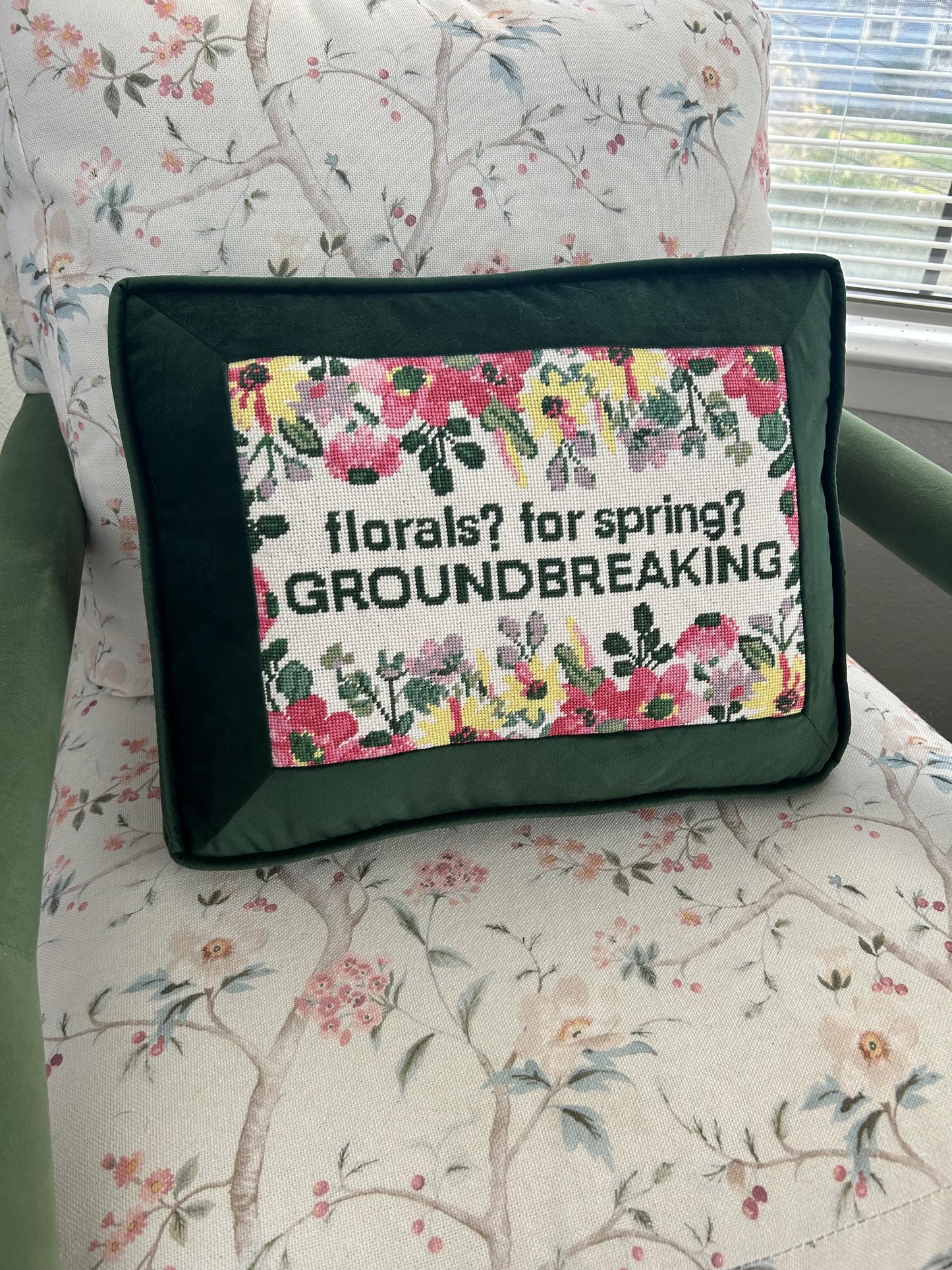 Floral-themed pillow with text on a floral-patterned chair