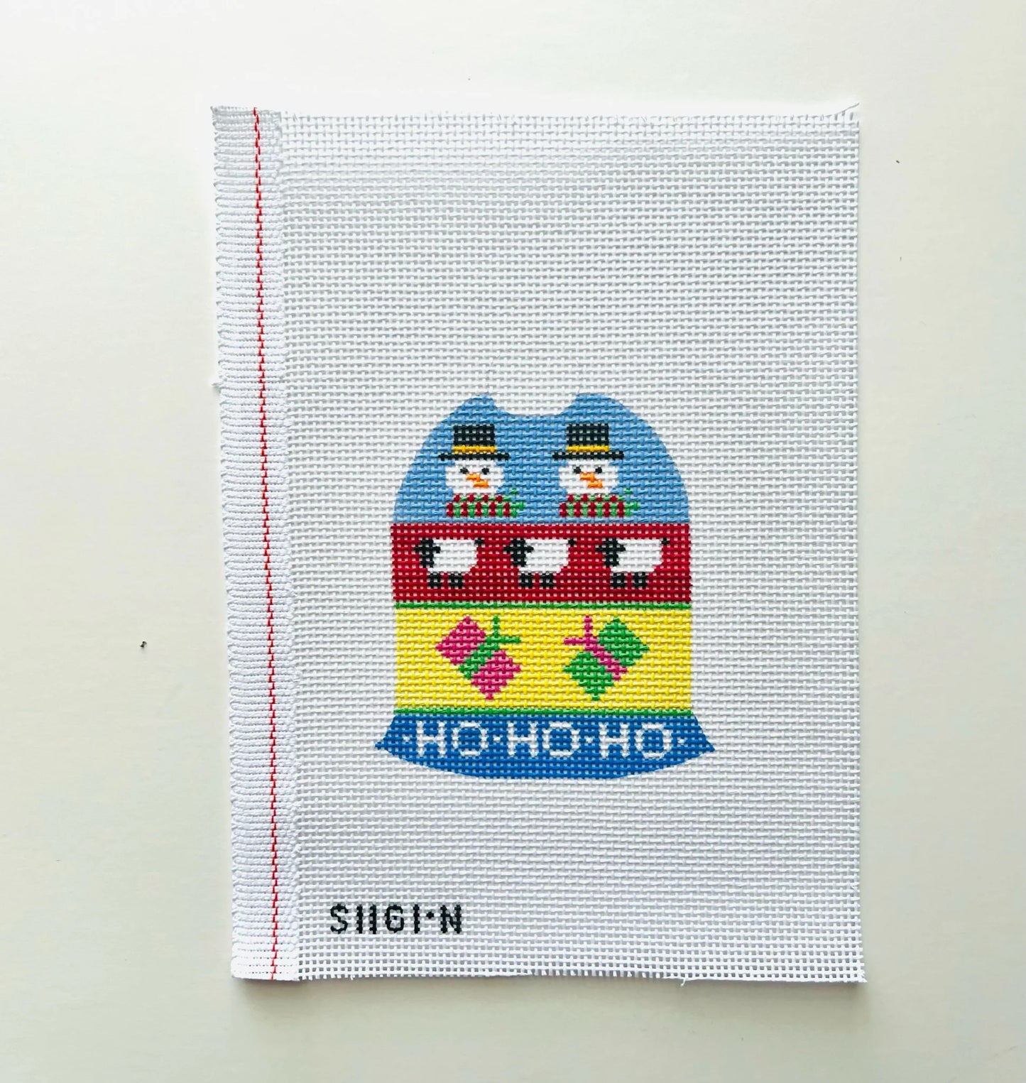 A square white needlepoint canvas featuring a colorful Christmas train design with snowmen and the text 'HO-HO-HO' 