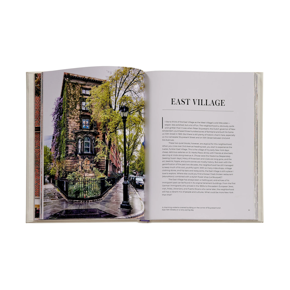 Open book showing a photograph of an urban street scene with trees and buildings, labeled 'East Village'.