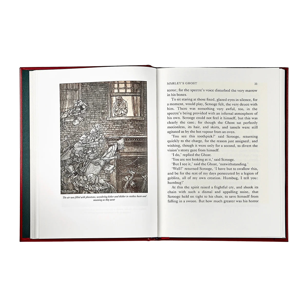 An open book with a dark red cloth-bound cover, showing printed text and a black-and-white illustration on the left page, photographed against a plain white background.