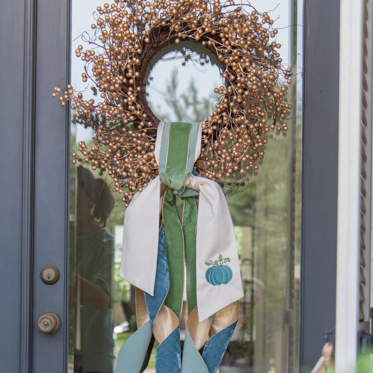 gold berry wreath on door with ribbons