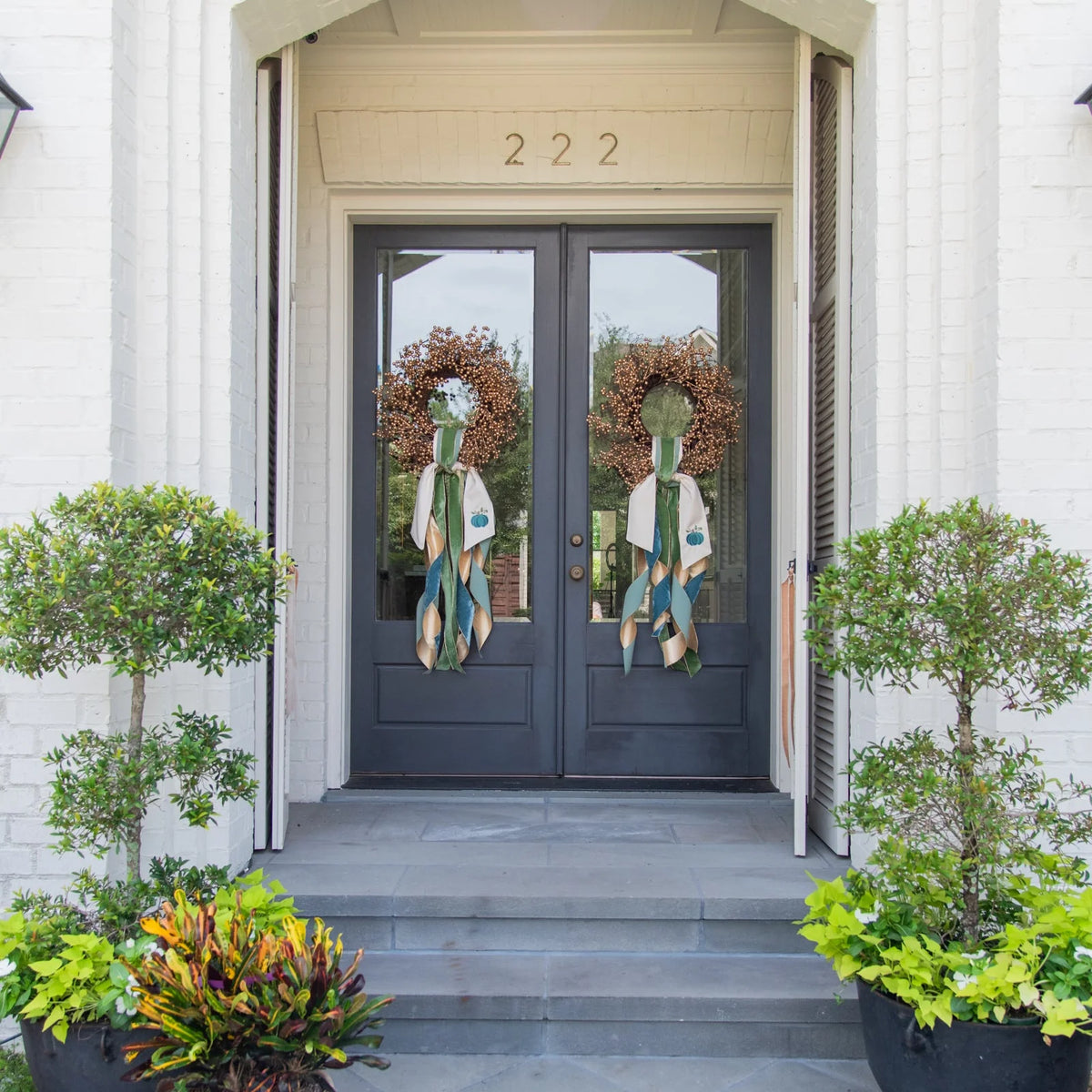 gold berry wreath on door with ribbons