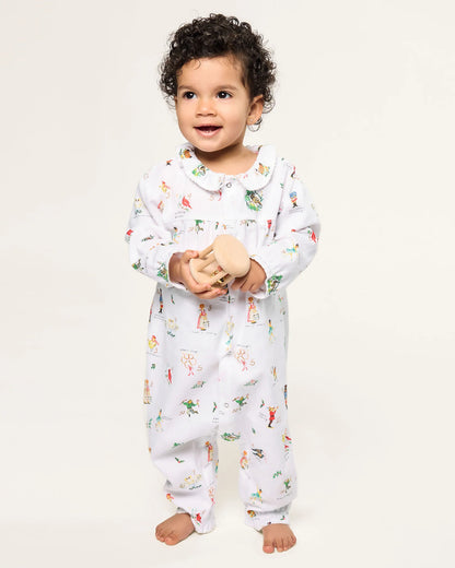 Child wearing a white onesie with colorful patterns on a plain background