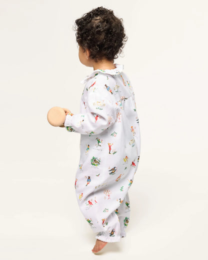 Child wearing a white onesie with colorful animal prints on a white background