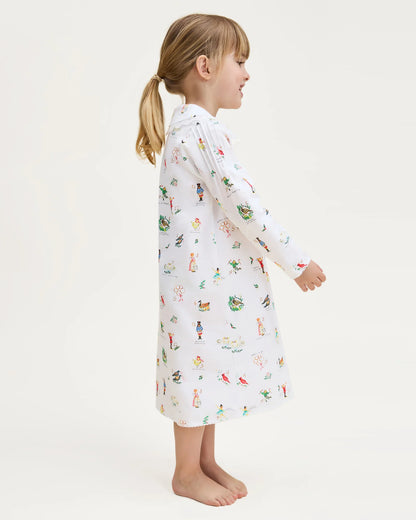 Child wearing a long-sleeve nightshirt with a pattern on a white background