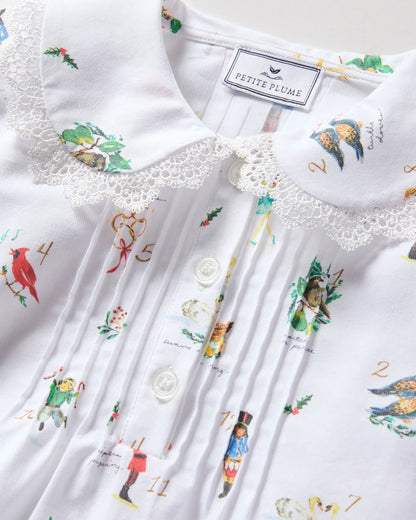 White shirt with colorful embroidered designs and 'Petite Plume' label.