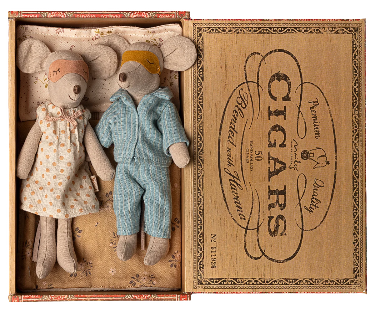 Two toy mice, a girl in a dress and a boy in overalls, inside an open cigar box with decorative text.
