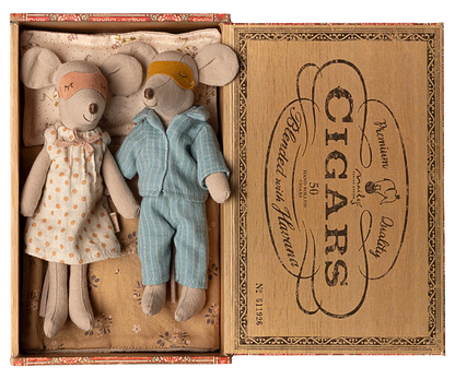 Two toy mice, a girl in a dress and a boy in overalls, inside an open cigar box with decorative text.