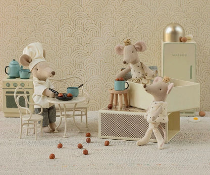 Toy mice in a kitchen setting with a patterned wallpaper background