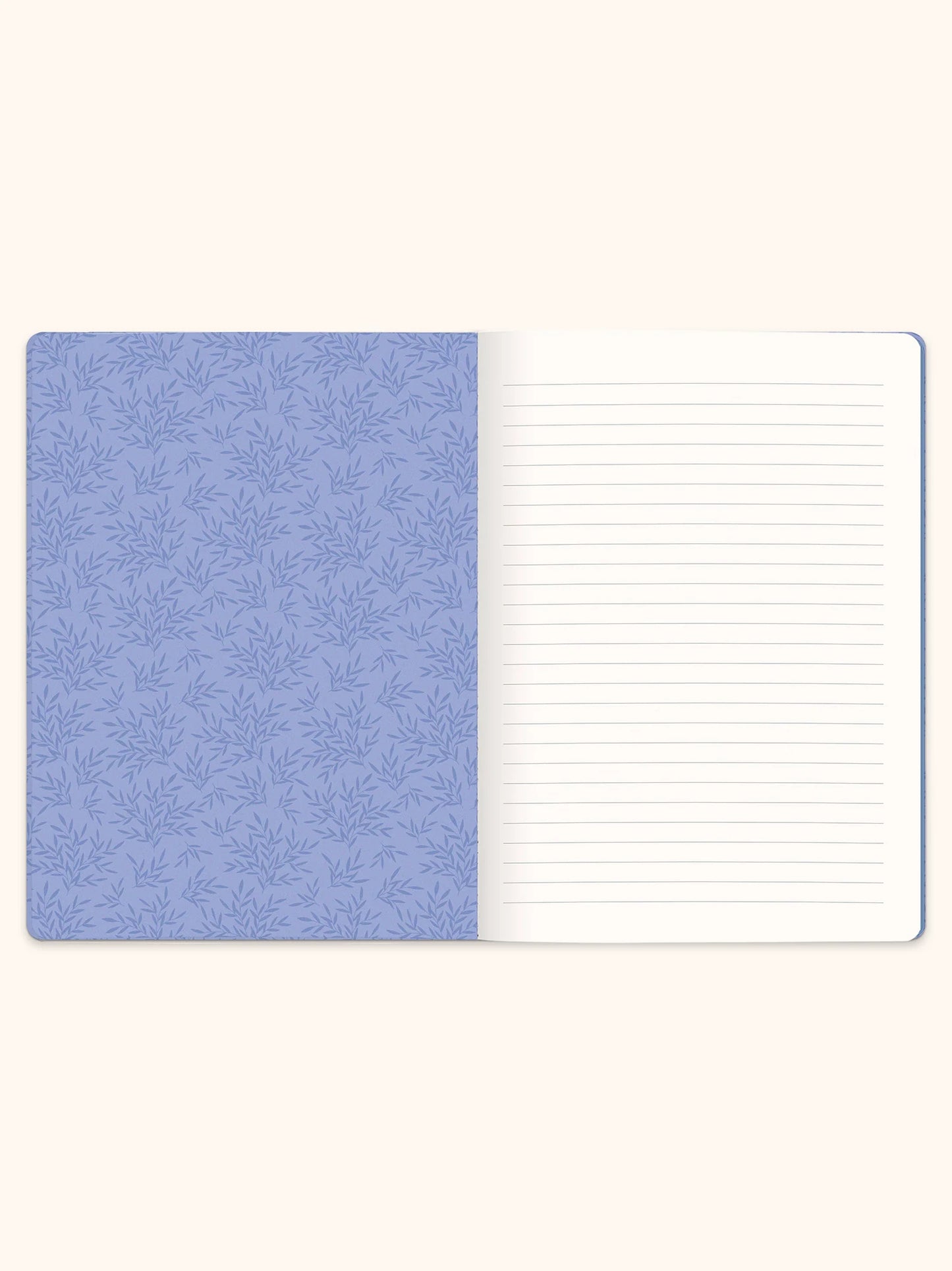 An open lined notebook with a light blue patterned cover on the left and blank white lined pages on the right, shown against a warm off-white background.