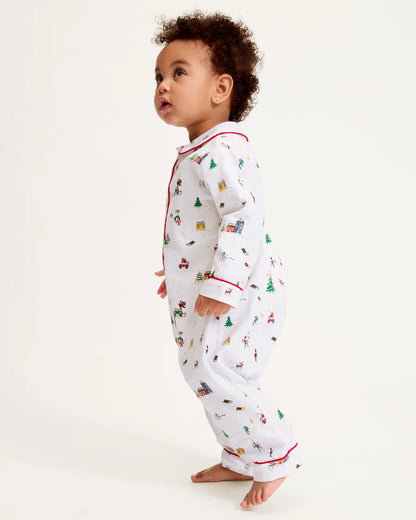 Baby wearing a white onesie with Christmas patterns on a white background