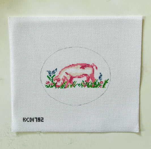 Cross-stitched design of a pig on a white fabric canvas with a circular border.