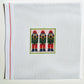 Cross-stitched design of three nutcrackers on a white fabric background