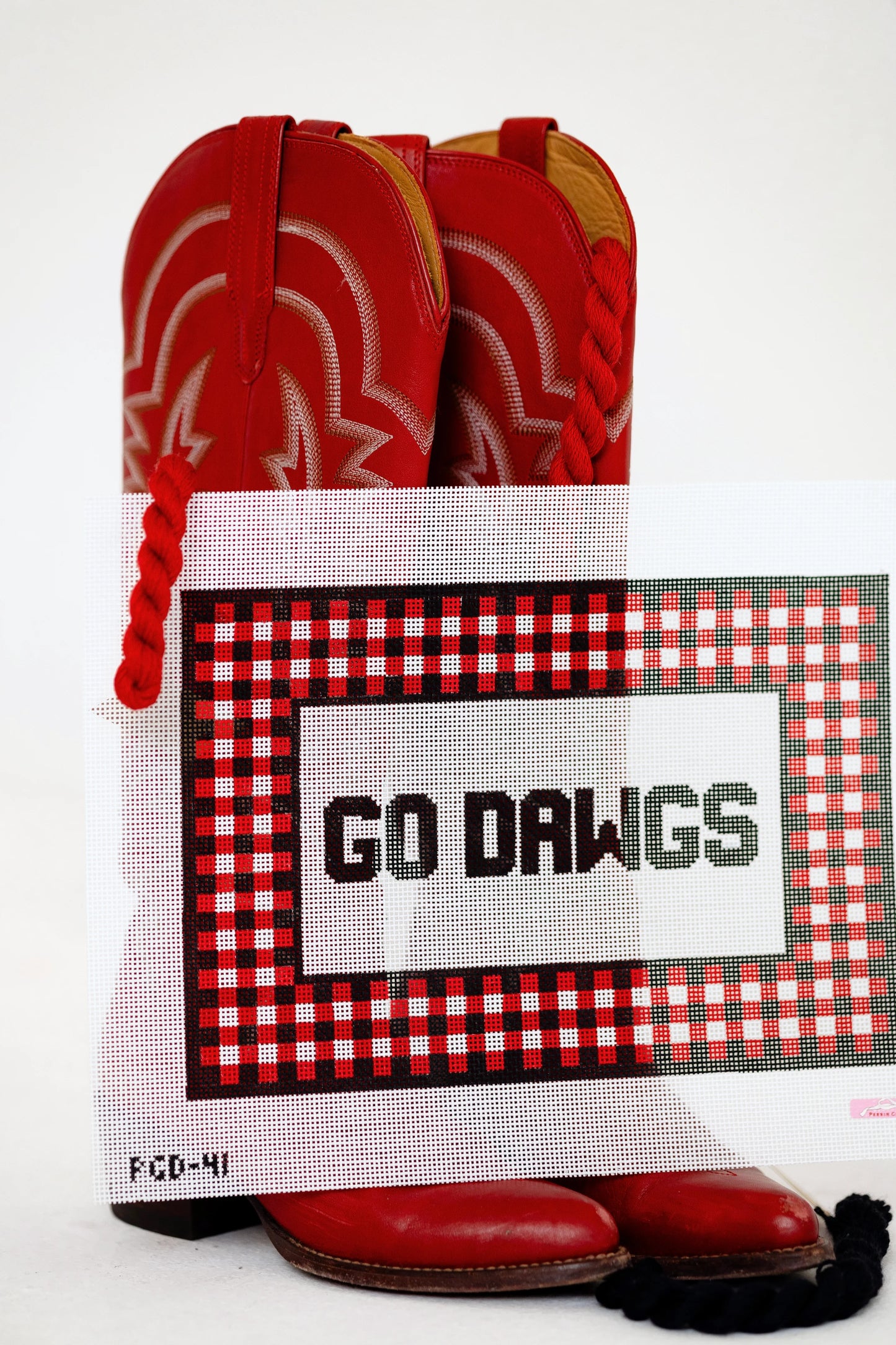 Red cowboy boots with a 'GO DAWGS' sign on a white background
