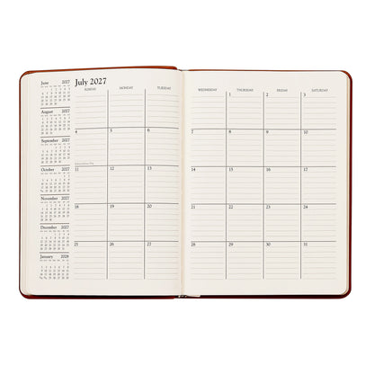 An open hardcover planner or journal showing a weekly calendar layout for July 2027, with lined daily writing pages and printed monthly calendars on the left side, photographed on a plain white background.