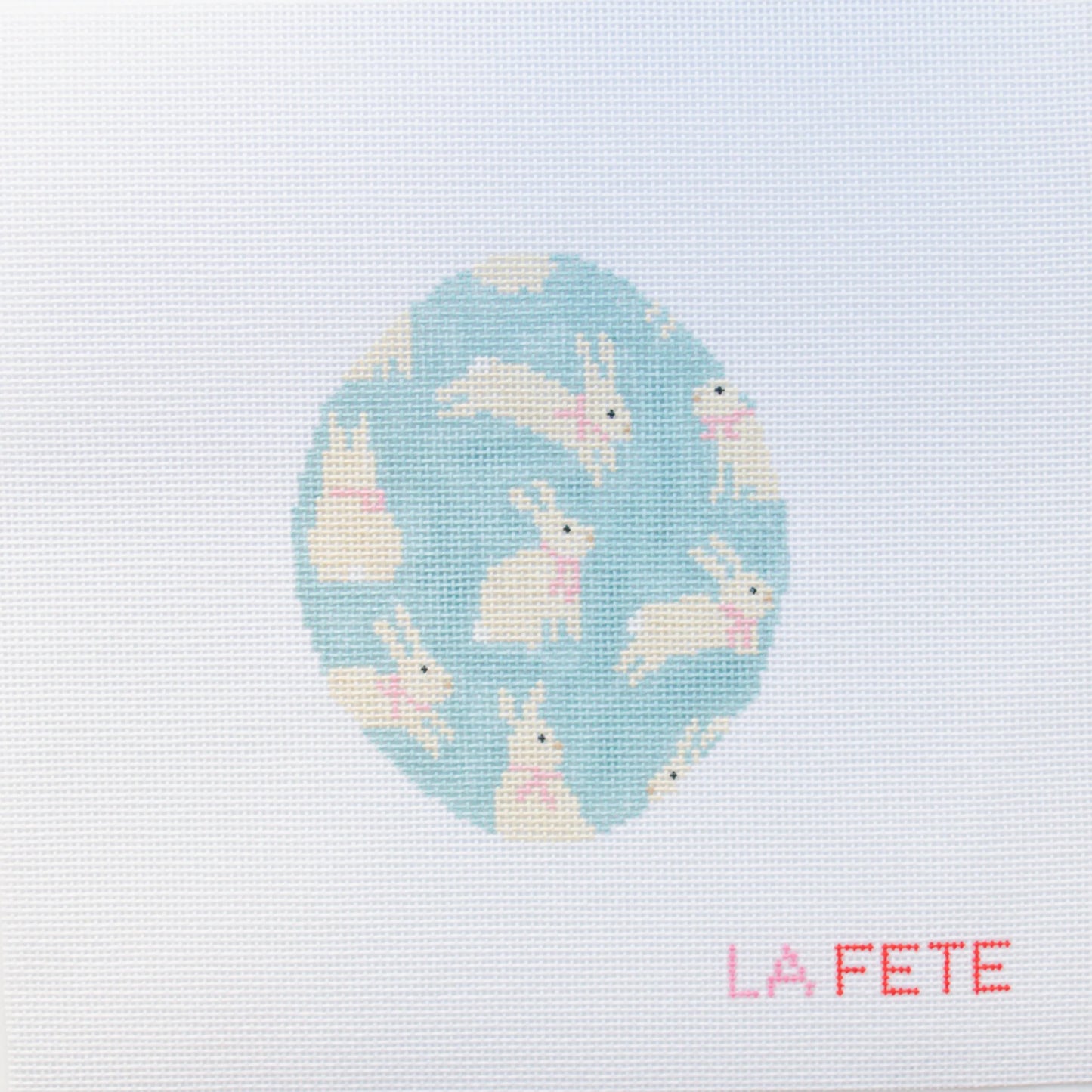 needlepoint design of bunnies on a blue background with 'La Fete' branding.