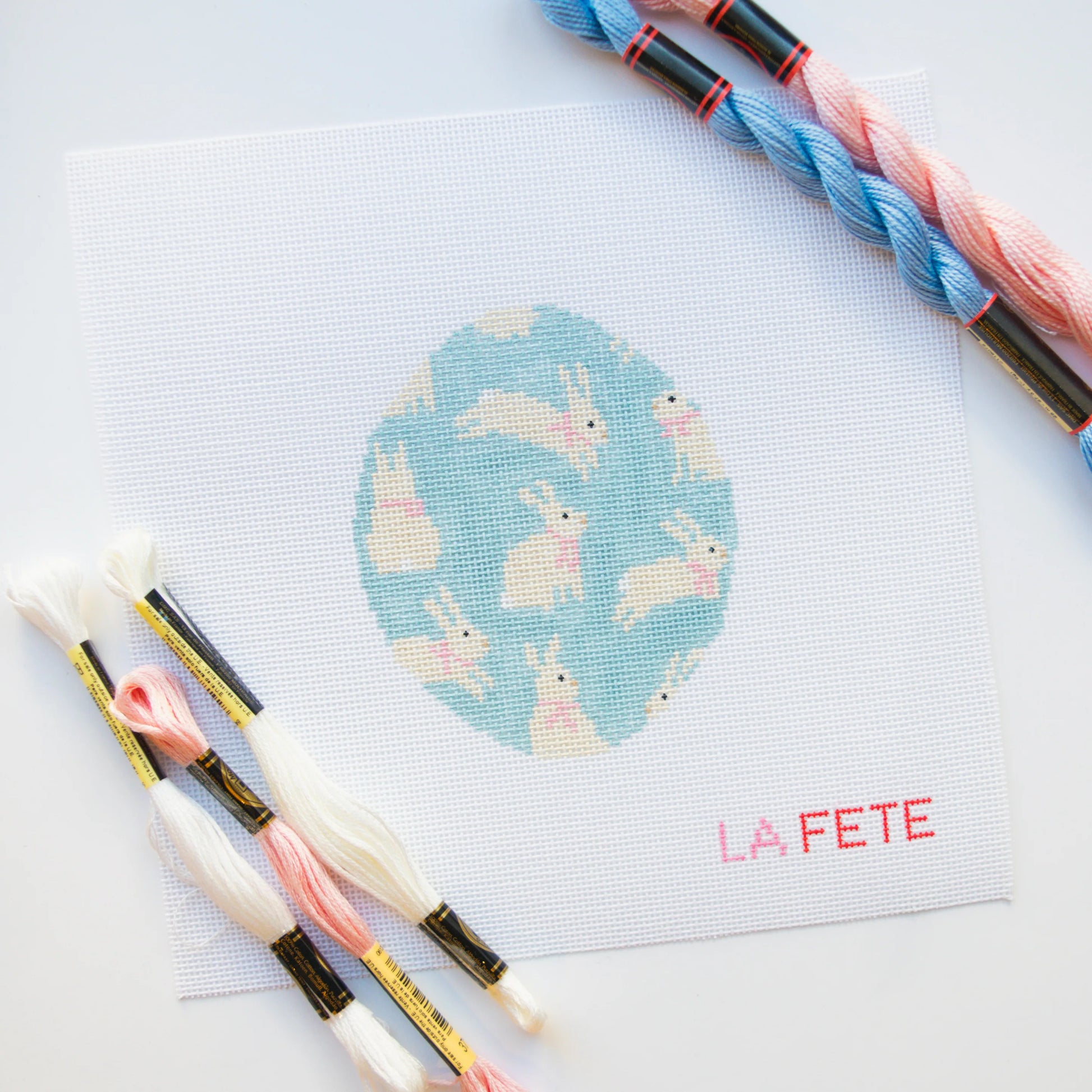 needlepoint kit with thread skeins on a white background