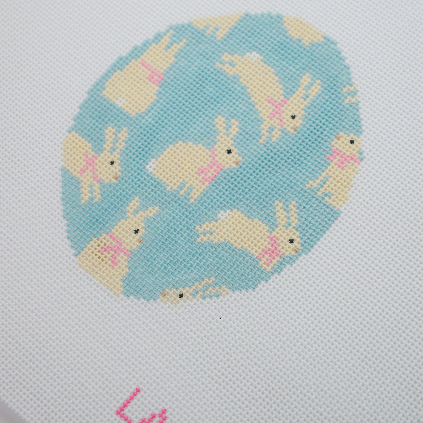 needlepoint pattern of bunnies on a blue background