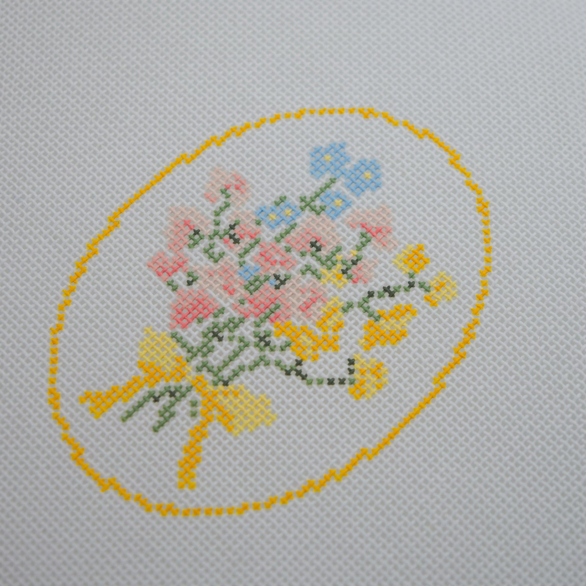needlepoint floral design on fabric with a yellow border