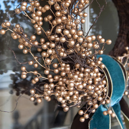 gold berry wreath on door with ribbons