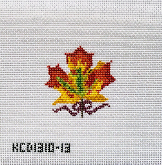 Embroidered maple leaf design on fabric with a visible brand label.