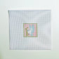 Cross-stitched design on fabric with a light blue background