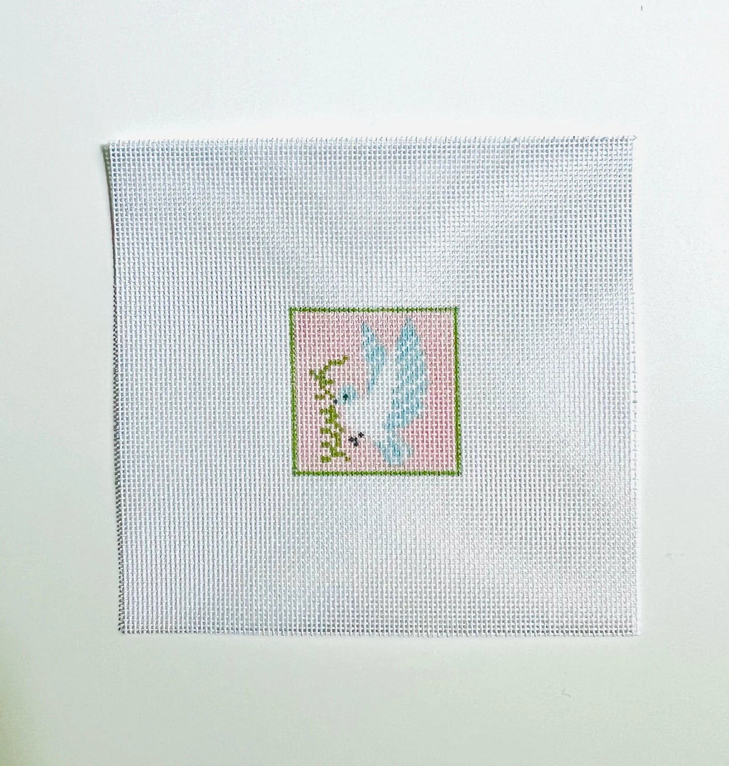 Cross-stitched design on fabric with a light blue background