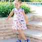 Young girl in a patterned dress standing on steps outdoors