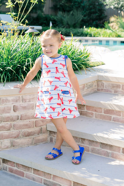 Young girl in a patterned dress standing on steps outdoors
