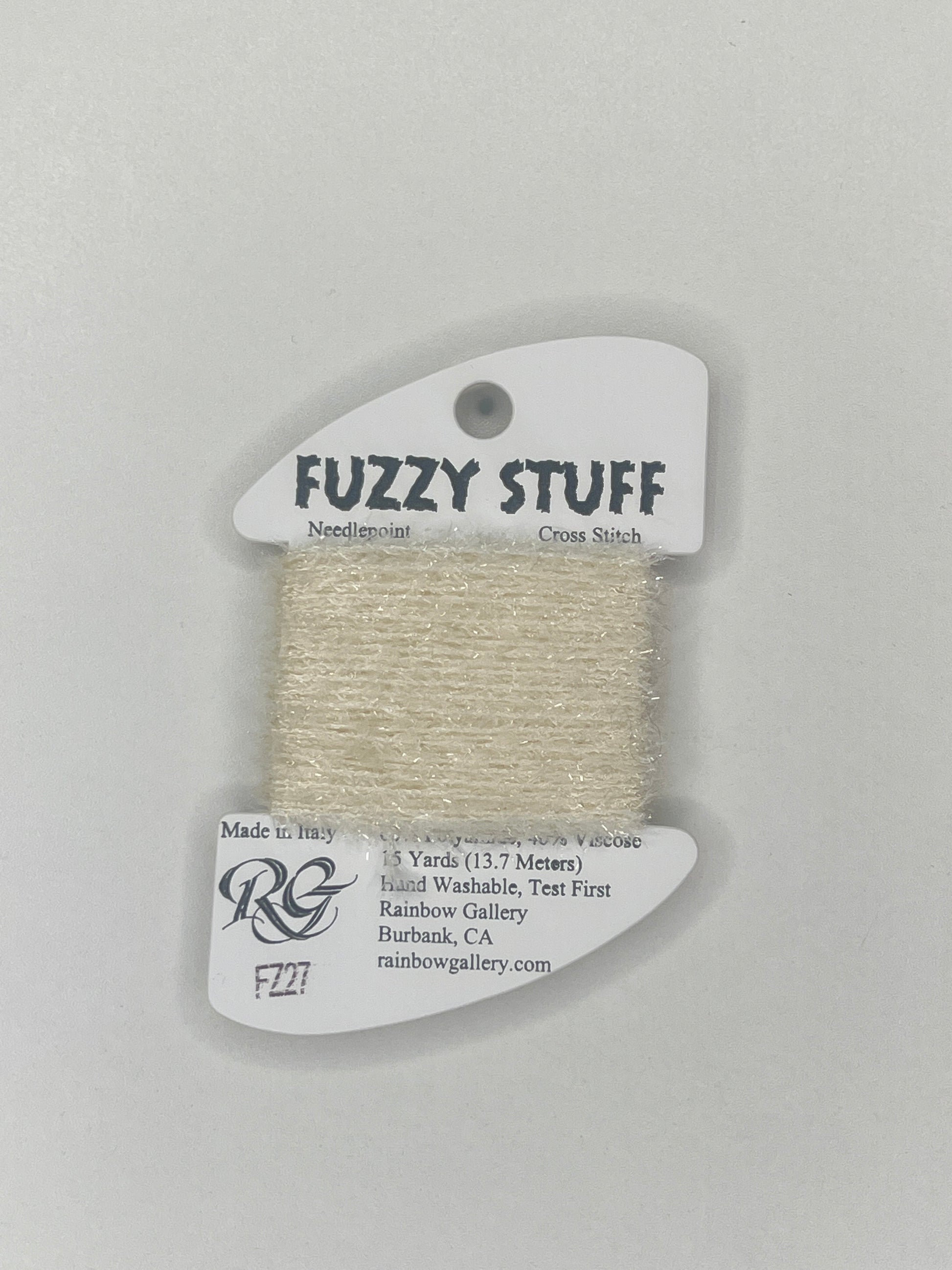 Spool of beige yarn with 'Fuzzy Stuff' label on a gray background