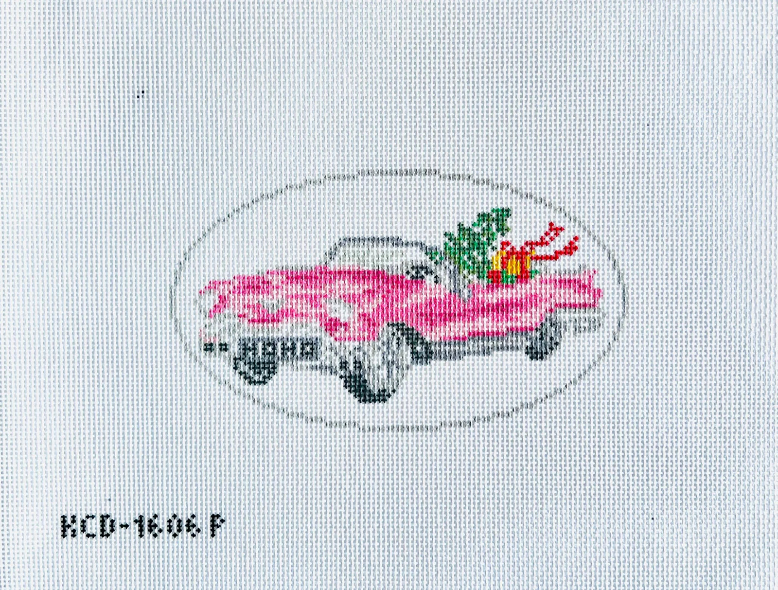 Cross-stitched pink car with flowers on a white fabric background