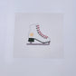 Cross-stitched ice skate on a white fabric background