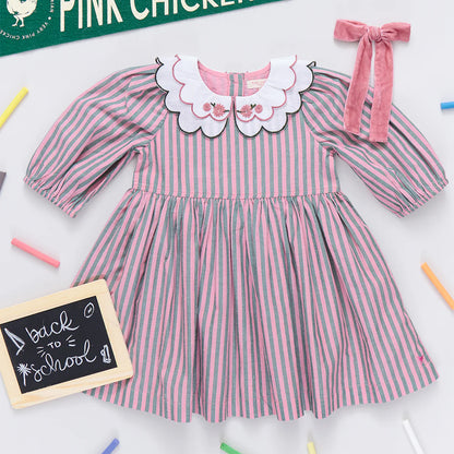 Pink and white striped dress with a large collar on a white background, surrounded by colorful crayons.