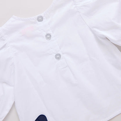 White baby onesie with buttons on a light gray background