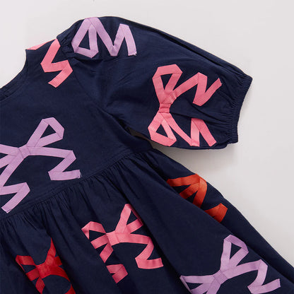 Navy blue dress with pink and red geometric patterns on a white background