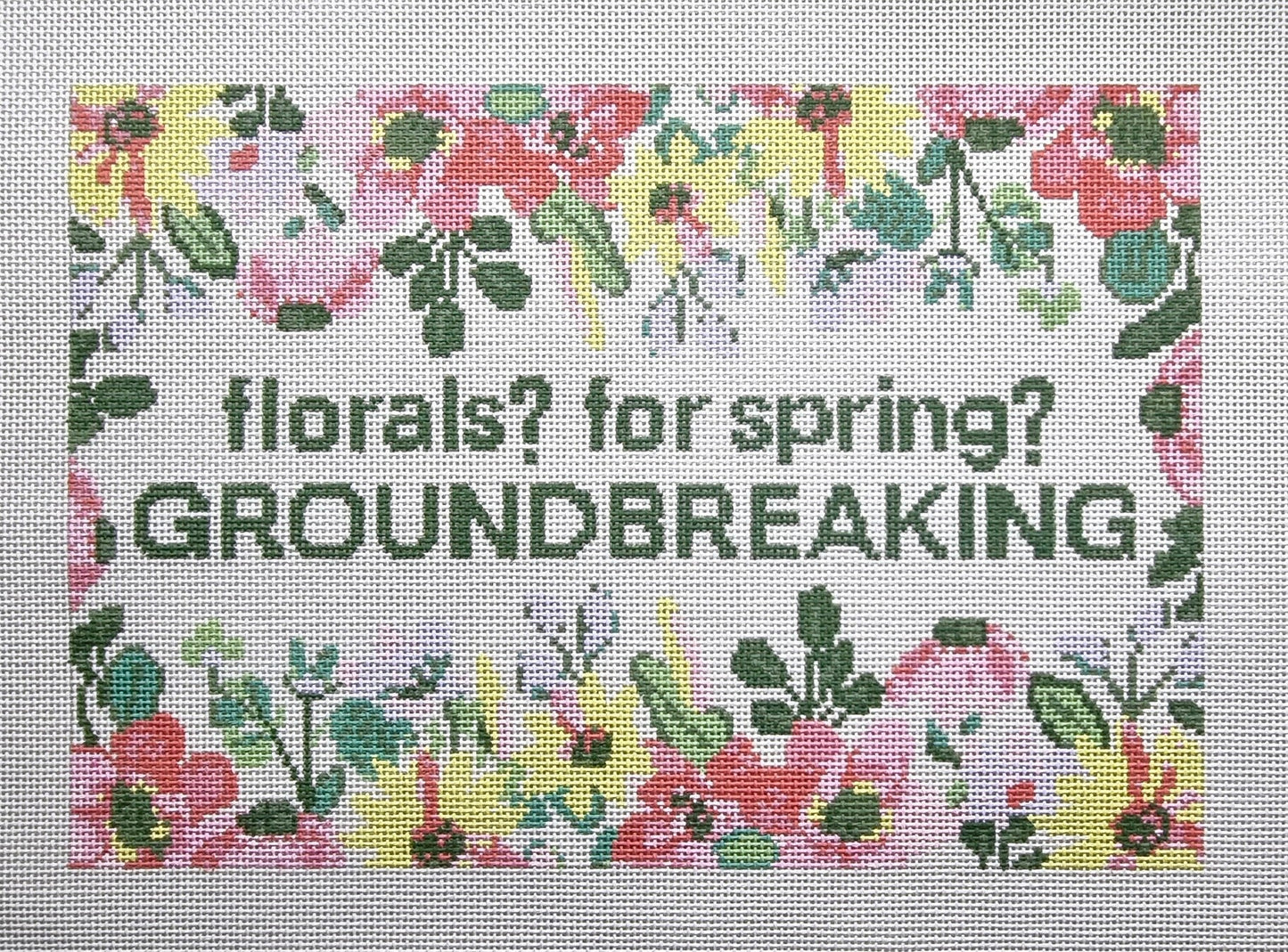 needlepoint pattern with floral design and text 'florals? for spring? GROUNDBREAKING'.