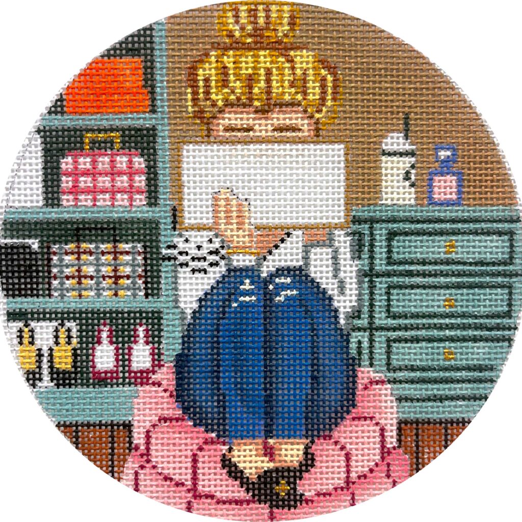 Circular needlepoint or cross-stitch design of a person in a blue coat and pink dress with a cityscape background.