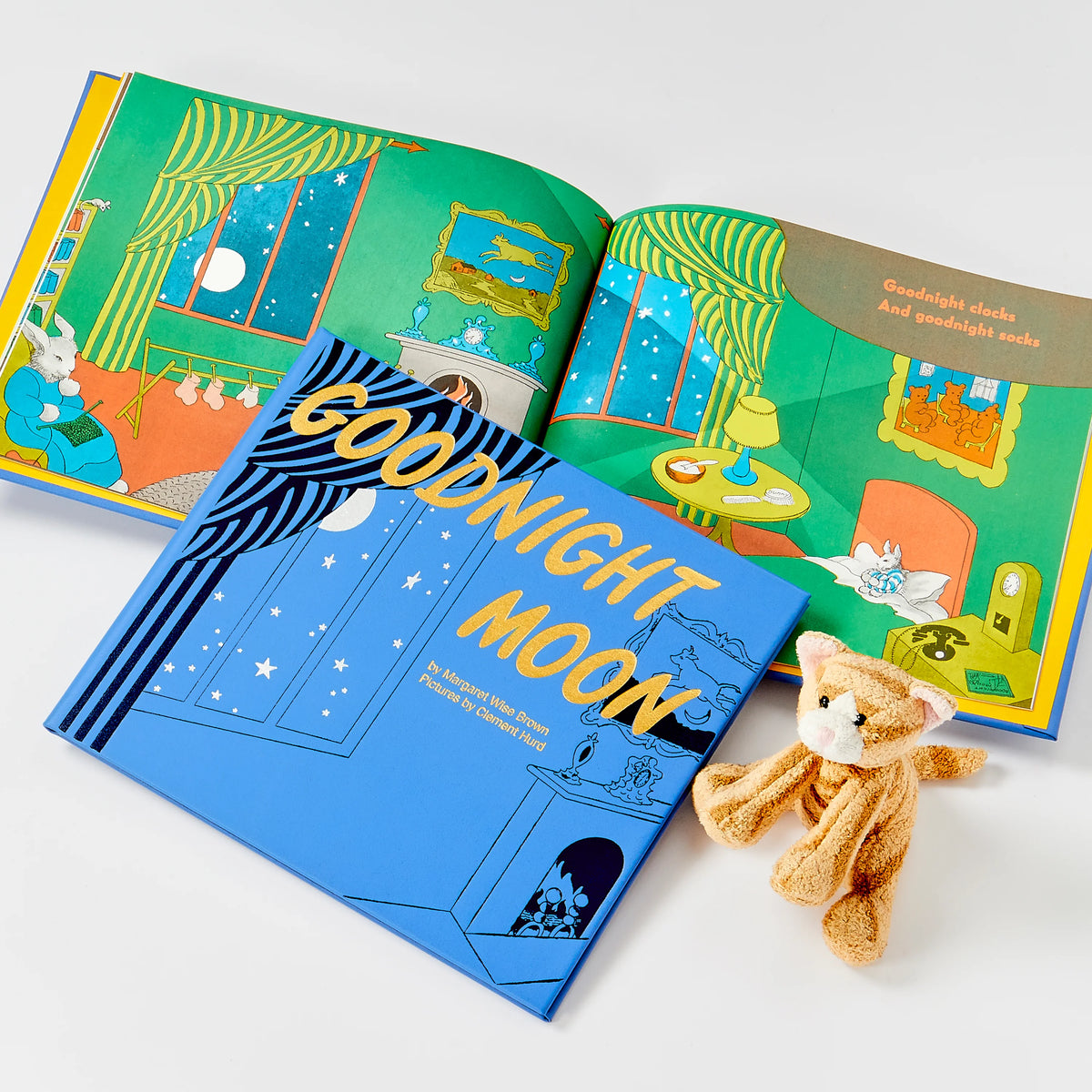 Open book titled 'Goodnight Moon' with a teddy bear on a white background