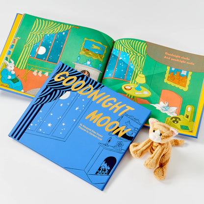 Open book titled 'Goodnight Moon' with a teddy bear on a white background