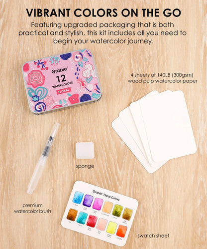 Grabiie watercolor kit with packaging, paper, brush, sponge, and swatch sheet on a wooden surface.