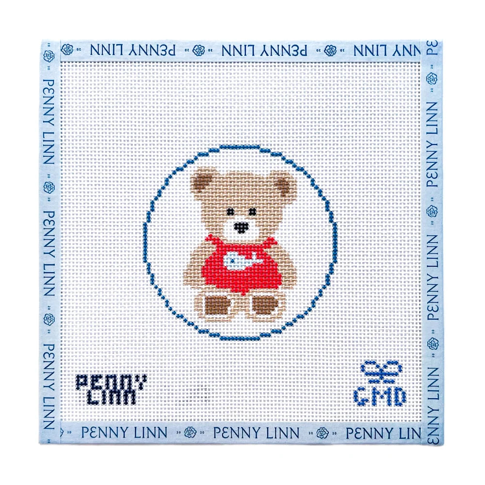 A cross-stitch canvas design featuring a teddy bear in a red dress inside a blue circle, surrounded by a blue border with 'PENNY LINN' text. The name 'PENNY LINN' is also stitched at the bottom left, and 'CMD' is stitched at the bottom right.