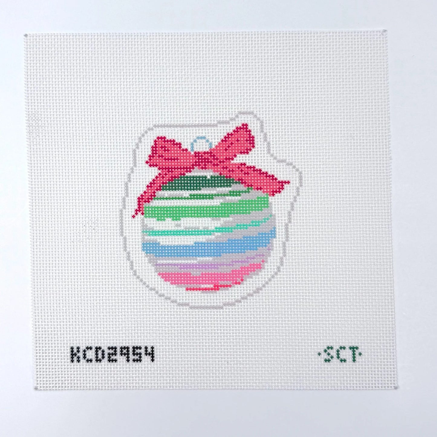 Cross-stitched design of a colorful striped ball with a pink bow on a white background.
